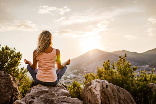 istock Young woman preforms yoga in mountains at sunset 1287837863