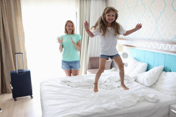 istock Cheerful girl jump high on bed. 1287837898