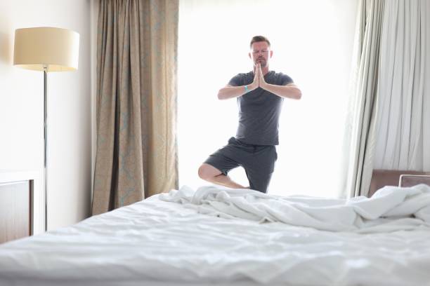 istock Man do morning exercises in room and meditates. 1287837911
