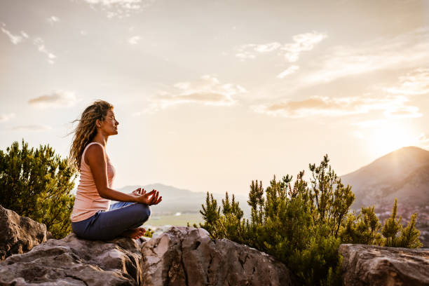 istock Young woman preforms yoga in mountains at sunset 1287837957