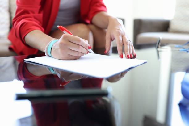Female hand hold pen and sign contract.