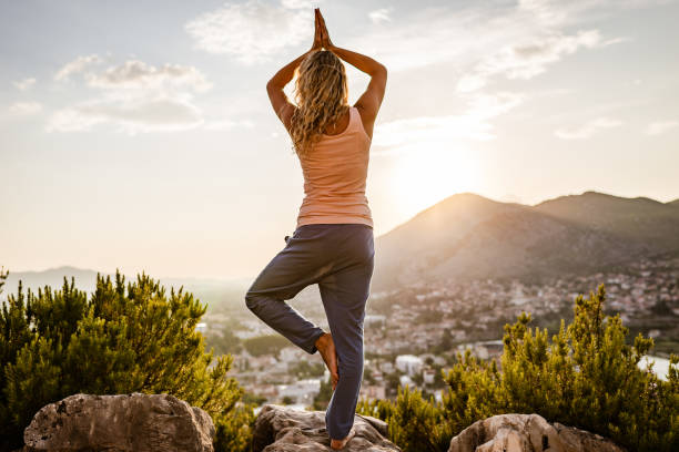 istock Young woman preforms yoga in mountains at sunset 1287838090