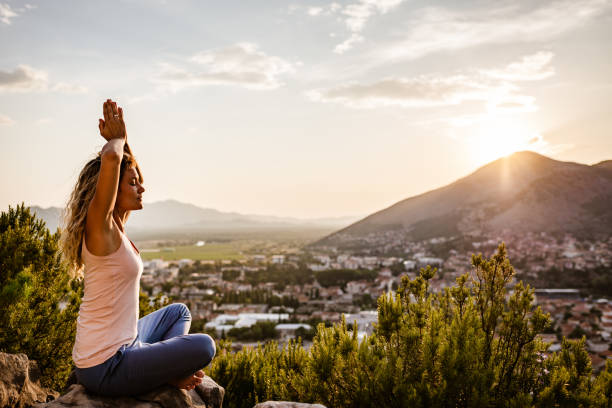 istock Young woman preforms yoga in mountains at sunset 1287838255