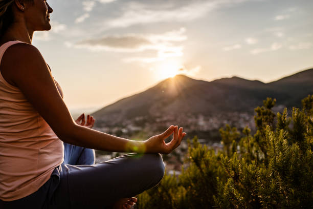 istock Young woman preforms yoga in mountains at sunset 1287838374