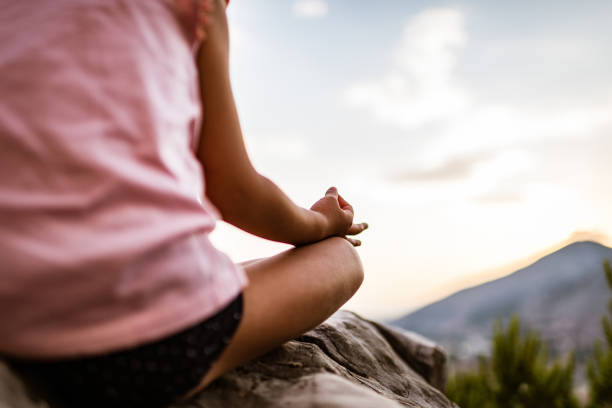 istock Young girl preforms yoga in mountains at sunset 1287838751