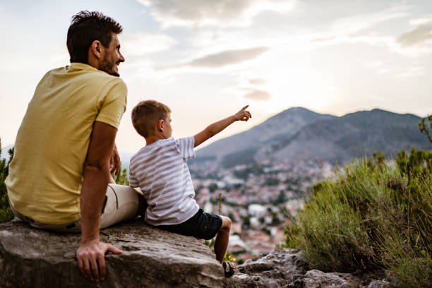 istock Young family relaxing in mountains at sunset 1287838823