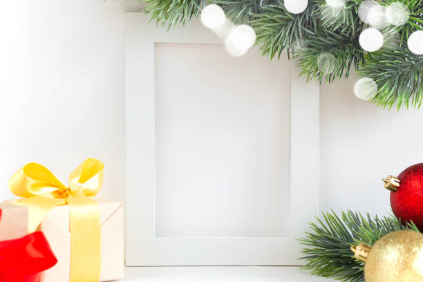 istock White frame mockup with Christmas decorative elements on the shelf. Portrait frame on a white wall. 1287838901