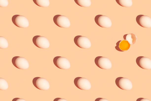 istock Seamless regular pattern of fresh eggs on a pastel orange background. Hard light. Easter holiday concept. 1287839102
