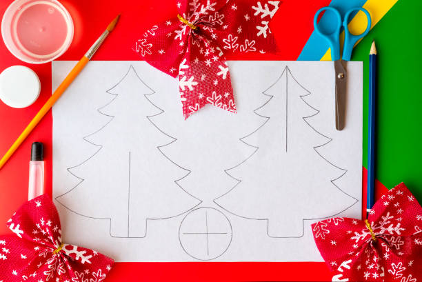 istock Christmas craft. DIY cardboard Christmas tree, step-by-step instructions on how to make a fir tree. Step 1 - Draw or copy two tree outlines and a base on cardboard 1287839162