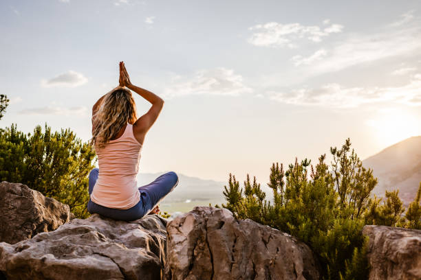 istock Young woman preforms yoga in mountains at sunset 1287839171