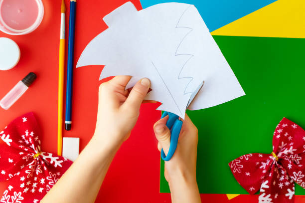 istock Christmas craft. DIY cardboard Christmas tree, step-by-step instructions on how to make a fir tree. Step 2 - Cut out the outlines of the Christmas trees 1287839185