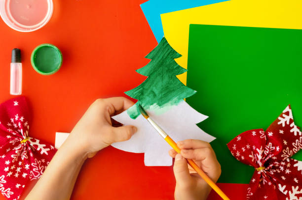 istock Christmas craft. DIY cardboard Christmas tree, step-by-step instructions on how to make a fir tree. Step 3 - Painting the contours with green (gouache) paint. 1287839204