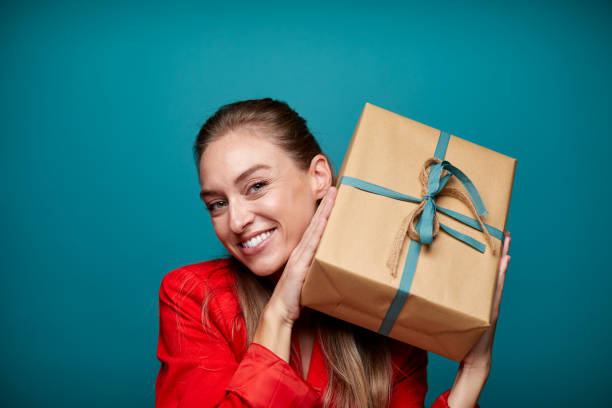 istock Woman holding a large Christmas gift with both hands. 1287844776