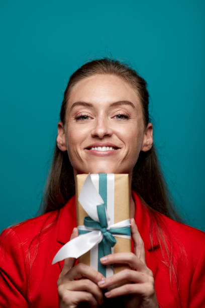 istock One woman happily holding a birthday gift. 1287844826