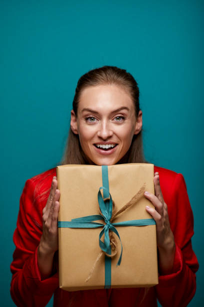 istock One woman happily holding a birthday gift. 1287844884