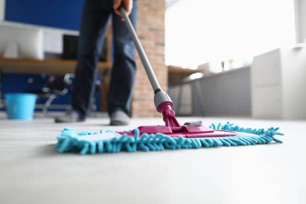 istock Man with mop washes floor in office closeup 1287845812