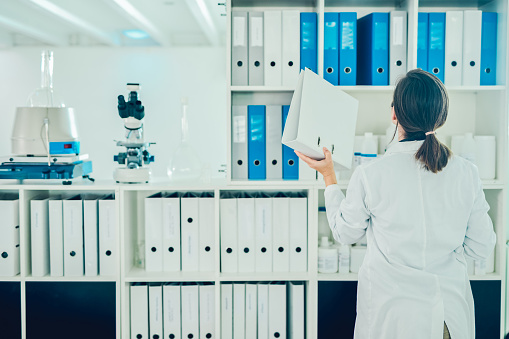 Shot of a scientist going through files while conducting research in a laboratory