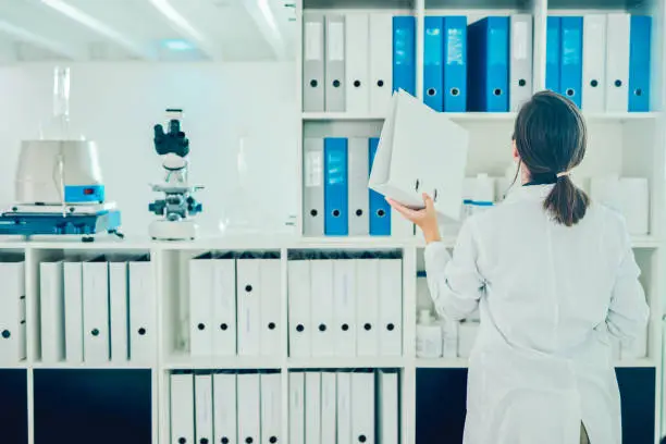 Shot of a scientist going through files while conducting research in a laboratory