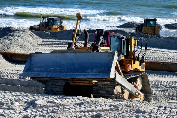 istock Bulldozer at the ocean beach fighting beach erosion 1287846035