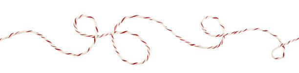 istock Curled white and red Christmas wrapping rope in a line arrangement isolated on white 1287846876