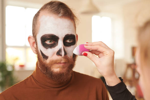 Using sponge while making mens face white