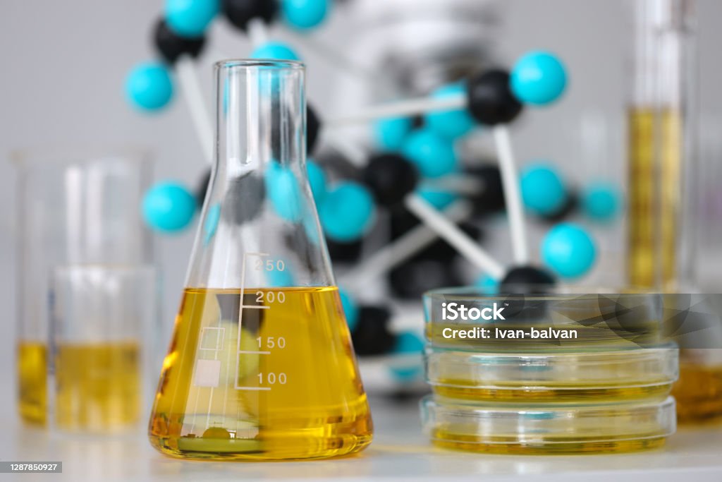 Glass test tubes with yellow viscous liquid stand on table in chemical laboratory closeup Glass test tubes with yellow viscous liquid stand on table in chemical laboratory closeup. Checking the quality of petroleum products refining concept. Gasoline Stock Photo