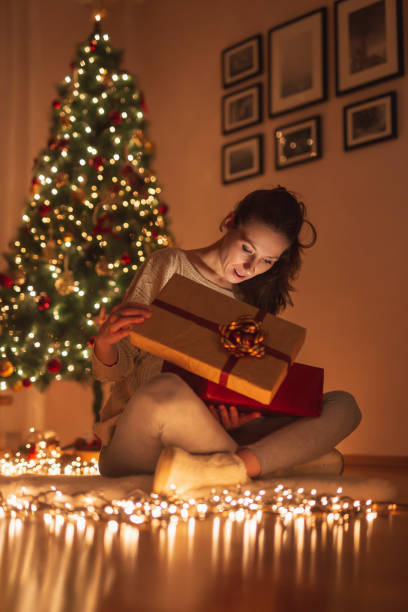 istock Woman opening presents for Christmas Eve 1287853724