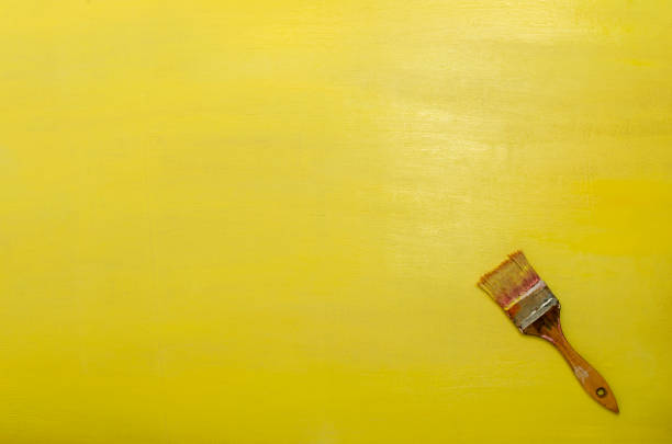 vue supérieure du vieux pinceau et du mur jaune peint frais. espace vide - retro revival manual worker textured effect ideas photos et images de collection