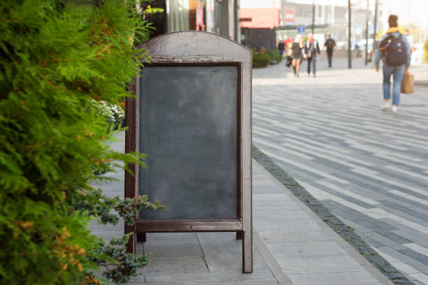 istock Signboard on the street. Empty menu board stand. Restaurant sidewalk chalkboard sign board. Freestanding A-frame blackboard near outdoor cafe. Copyspace for text, selective focus 1287857149
