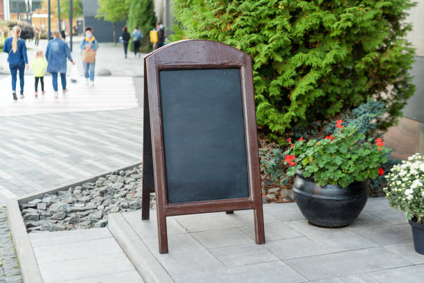 istock Signboard on the street. Empty menu board stand. Restaurant sidewalk chalkboard sign board. Freestanding A-frame blackboard near outdoor cafe. Copyspace for text, selective focus 1287857160