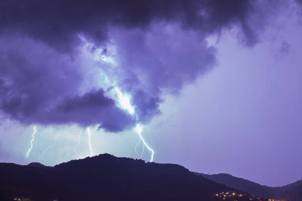istock Strong thunder-storm above night mountains and city. Large Bright Lightning Close up. Mediterranian winter night thunderstorm. Alanya, Turkey 1287859546