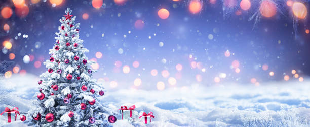 istock Snowy Christmas Tree With Red Ornament And Present Boxes In A Winter Landscape 1287860702