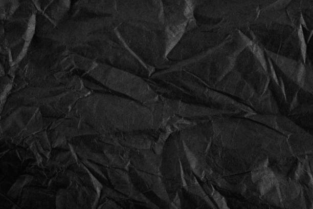 istock Background with Black crumpled sheet of paper with vignetting. 1287861288