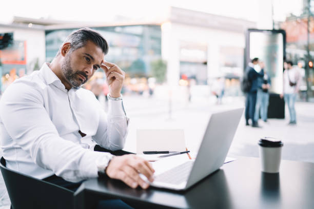 istock Middle aged businessman watching received video message pondering on strategy information during distance job in sidewalk, thoughtful male employee reading financial publication analyzing trade 1287863988