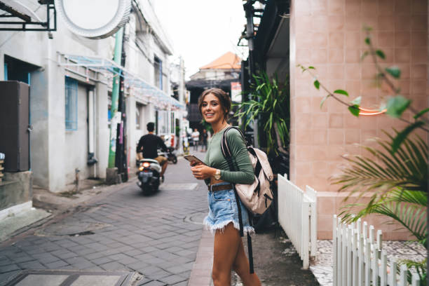 istock Smiling woman walking with smartphone 1287864016