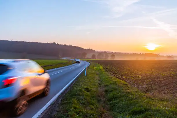 car driving on country road at sunset