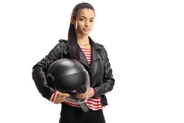 jeune motard féminin dans une veste en cuir retenant un casque - casque de moto photos et images de collection