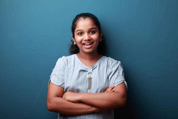 istock Excited  smiling young girl against a blue wall background 1287869883