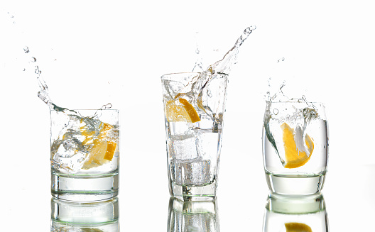Three slices of lemon splash into three refreshing glasses of gin and tonic (or similar clear drink).