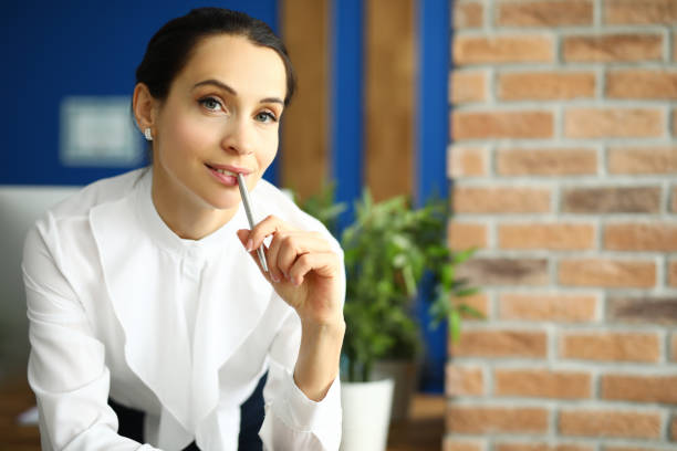 istock Employee holds a pen with her lips and thinks 1287872709