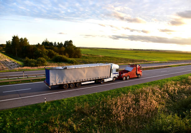 heavy recovery truck monta un camión semitrailer en carretera - towing tow truck truck semi truck fotografías e imágenes de stock
