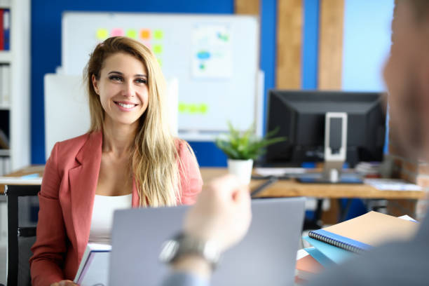 Beautiful employee sits in front of her boss