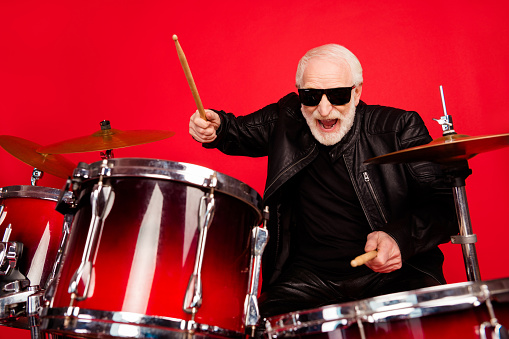 Portrait of crazy funky old man punk rocker play drum enjoy night club festival recording, studio composition wear leather jacket isolated over bright shine color background