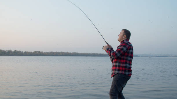 istock Male angler taking selfie with fish near water 1287874169