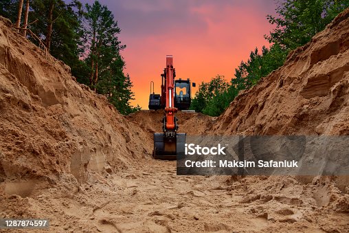 istock Excavator dig trench at forest area on amazing sunset background 1287874597