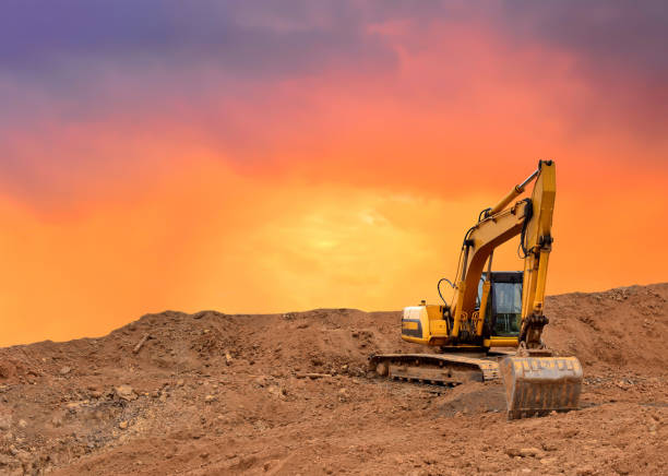istock Excavator working on earthmoving at open pit mining on amazing sunset background 1287875850