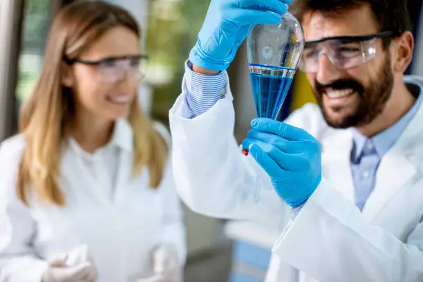 Photo of Researcher working with blue liquid at separatory funnel