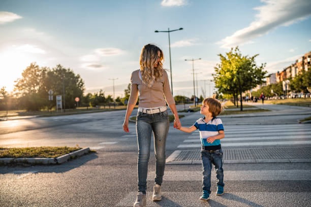 istock Mom and son crossing the road 1287878587