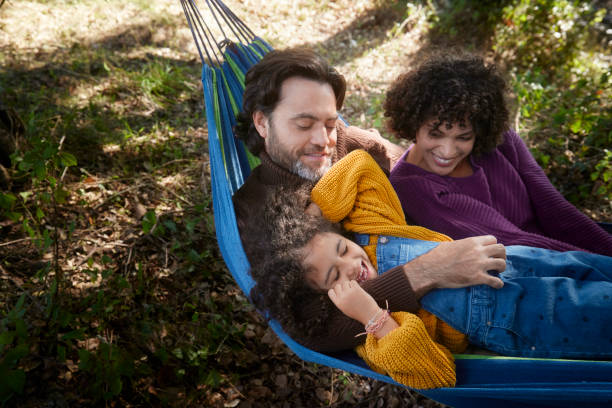 istock Family lying and playing on a hammock in the woods 1287882199