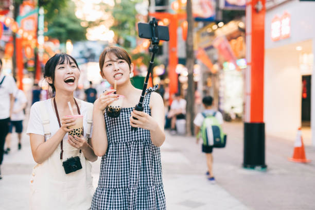 Asian influencers making a vlog in the city Young asian influencers making a vlog while walking in the city. With copy space. bubble tea photos stock pictures, royalty-free photos & images